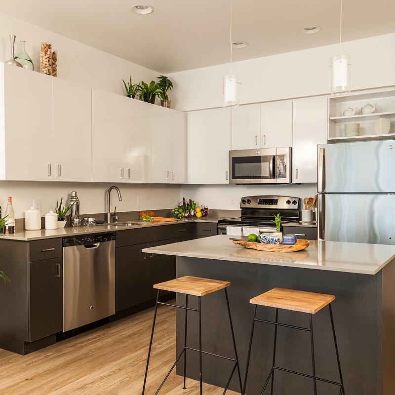 Rénovation façade maison : échafaudage et chantier Chantier de rénovation extérieure d'une maison moderne, échafaudages métalliques devant les façades couleur crème sous un ciel bleu avec nuages.