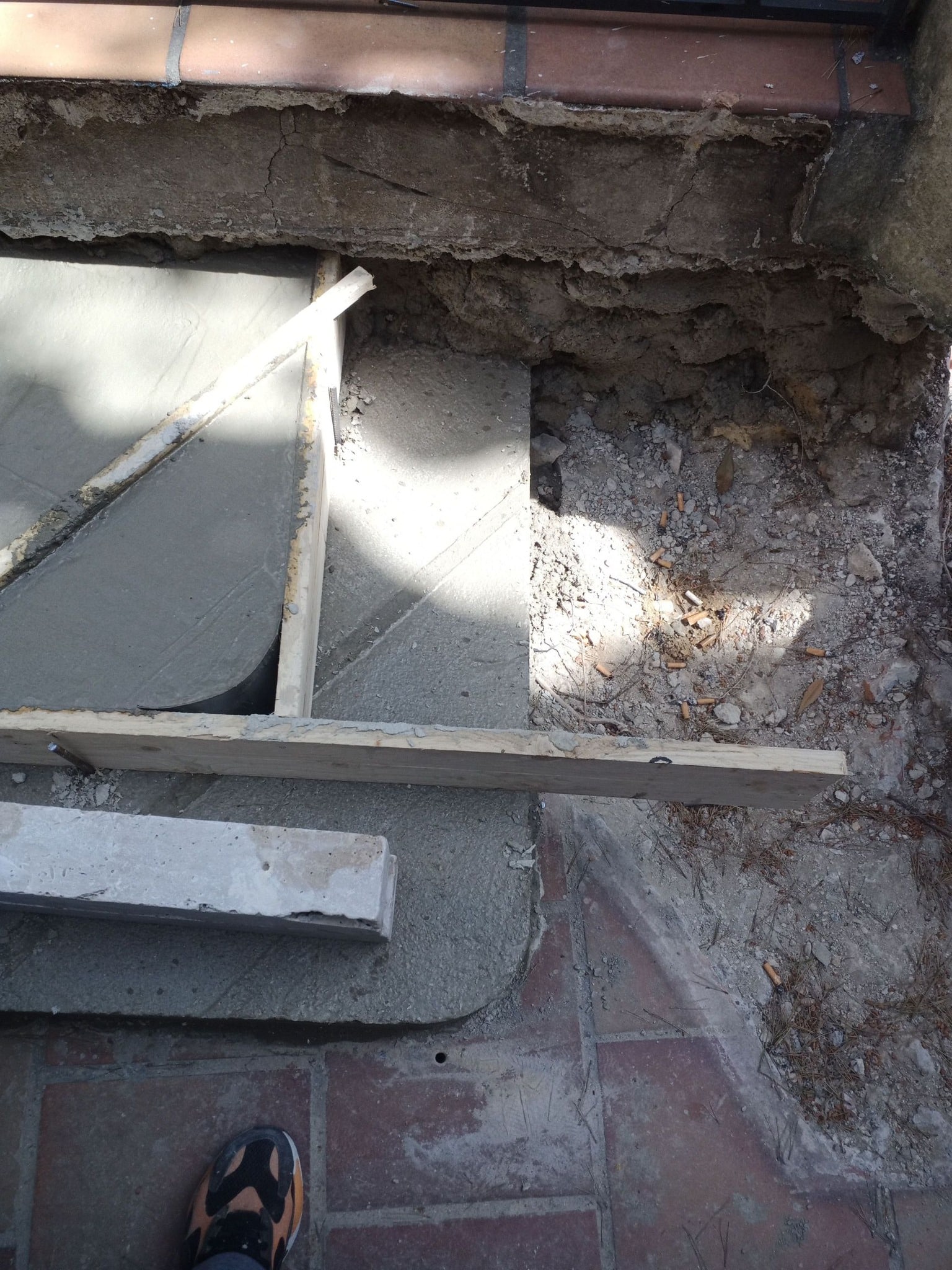 Coffrage en bois et béton frais pour la rénovation d'un escalier extérieur sur un chantier de maçonnerie.